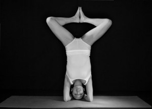 Woman standing on head in yoga pose with feet touching