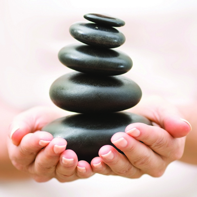 hands holding hot rocks for massage